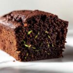 Close-up of a moist chocolate zucchini cake loaf, showing visible zucchini shreds.