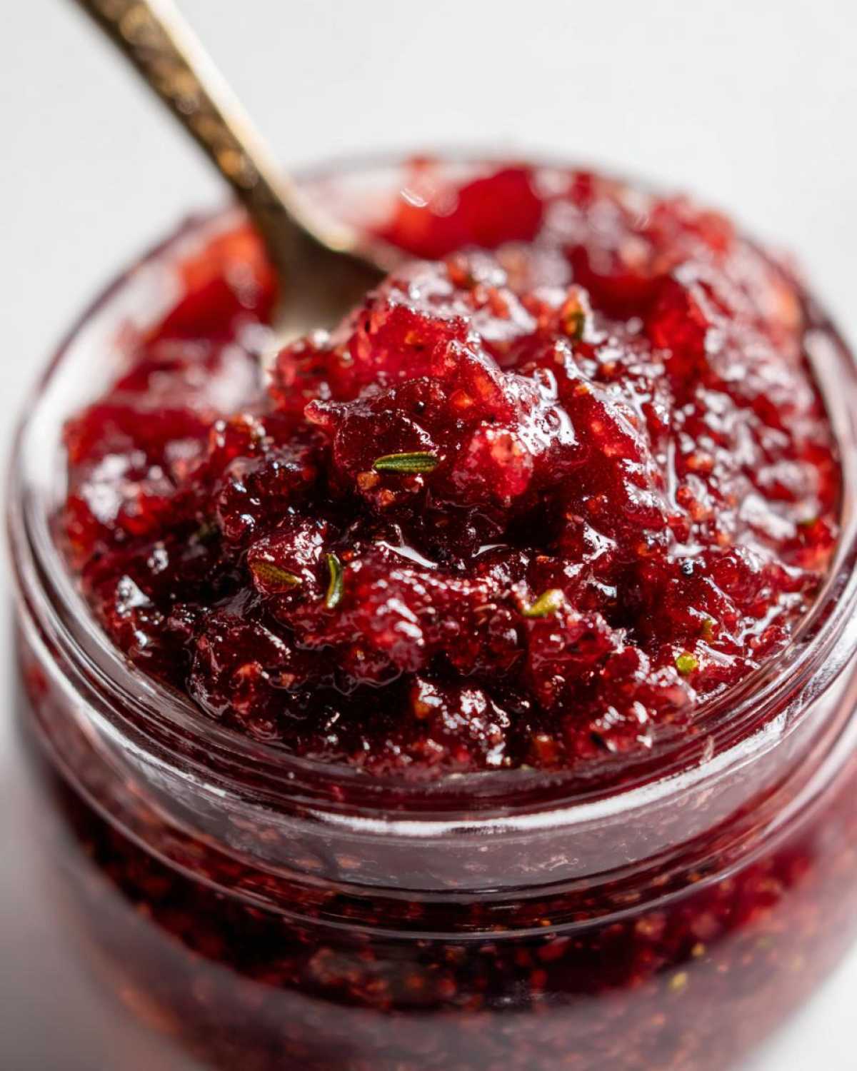 Close-up of homemade fig jam in a glass jar with a spoon. Delicious homemade fig jam.