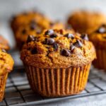 Close-up of pumpkin chocolate chip muffins on a wire rack, showcasing the texture and chocolate chips.