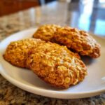 A plate of freshly baked pumpkin oatmeal cookies, golden brown and ready to eat.