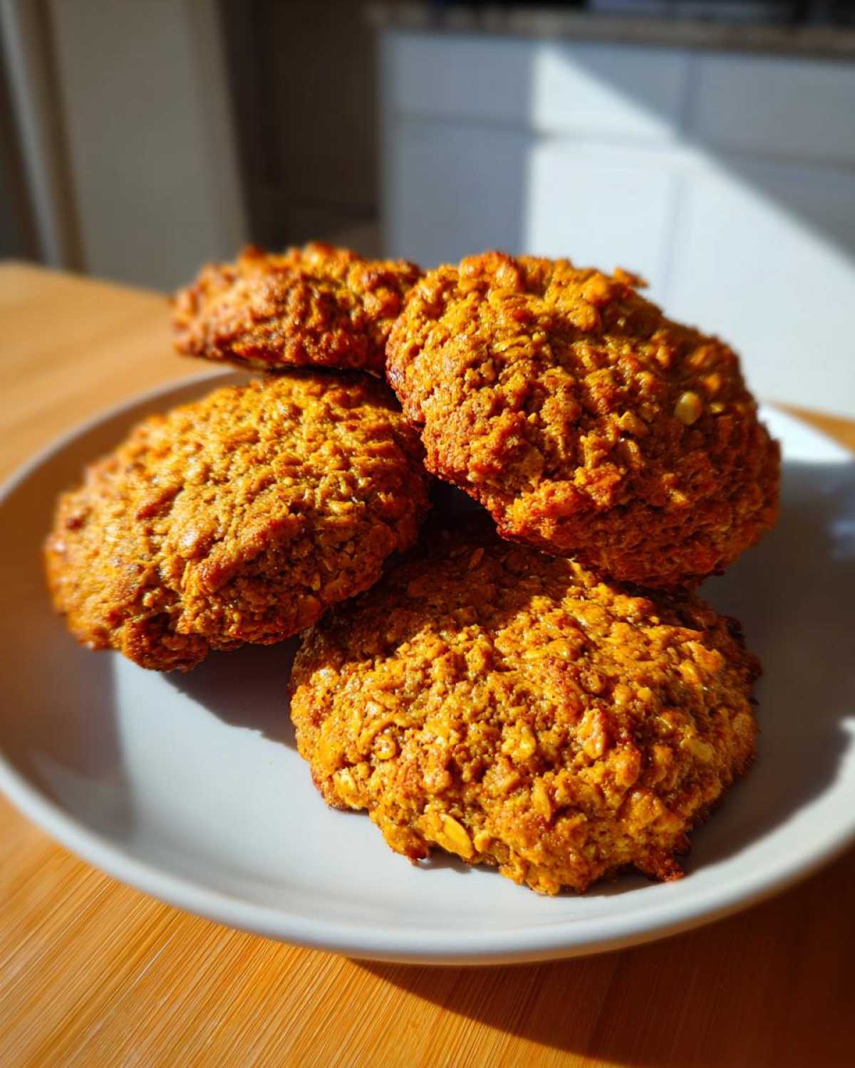 A plate of freshly baked pumpkin oatmeal cookies, showcasing their texture and warm color.