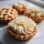 Close-up of apple pie cookies, some with lattice crust and others with decorative frosting.