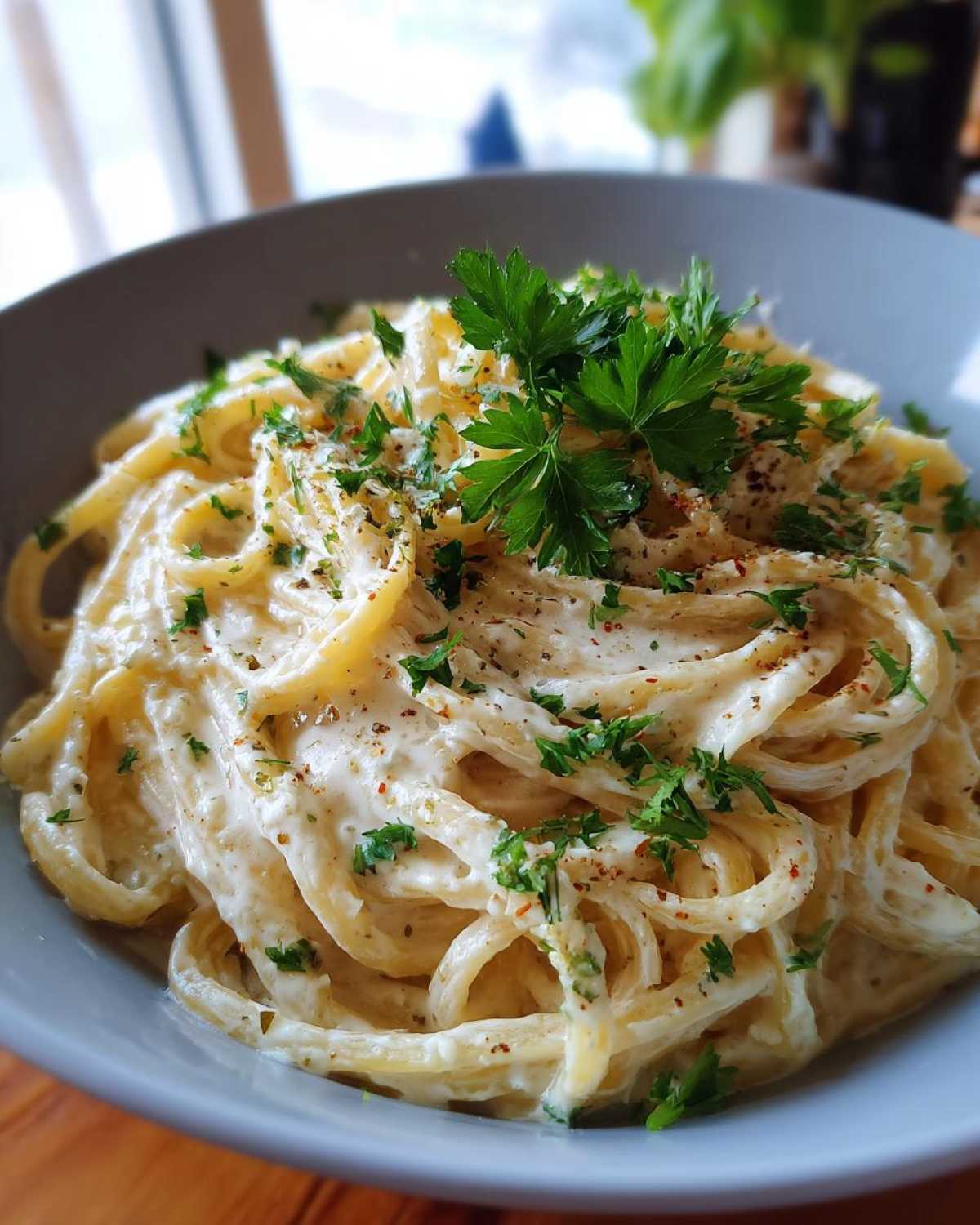 Bowl of Creamy Lemon Pasta, garnished with fresh parsley and spices, ready to eat.
