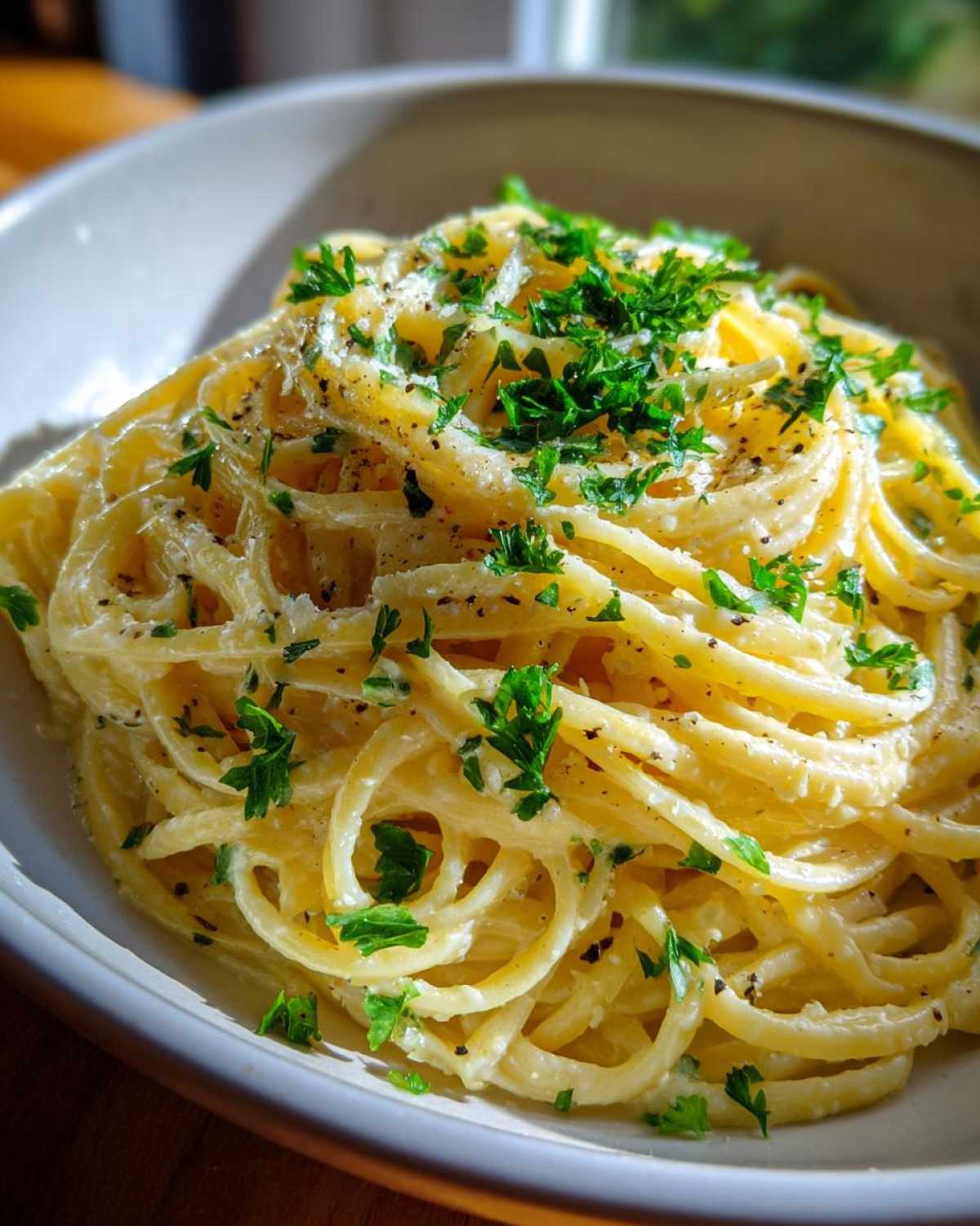 Bowl of Creamy Lemon Pasta, garnished with fresh parsley and black pepper.