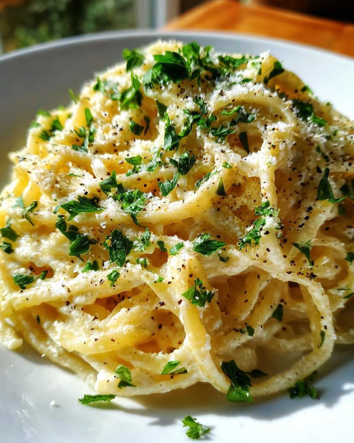 Close-up of Creamy Lemon Pasta, topped with fresh parsley and black pepper. A quick and easy meal.