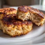 Close-up of crispy Tuna Patties on a white plate, one patty broken open to show the inside texture.