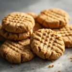 A stack of freshly baked Easy Peanut Butter Cookies, showing the classic criss-cross pattern.
