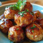 A stack of glazed honey garlic turkey meatballs garnished with parsley, ready to eat.
