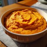 A bowl filled with creamy, vibrant pumpkin cream cheese, ready to be enjoyed.