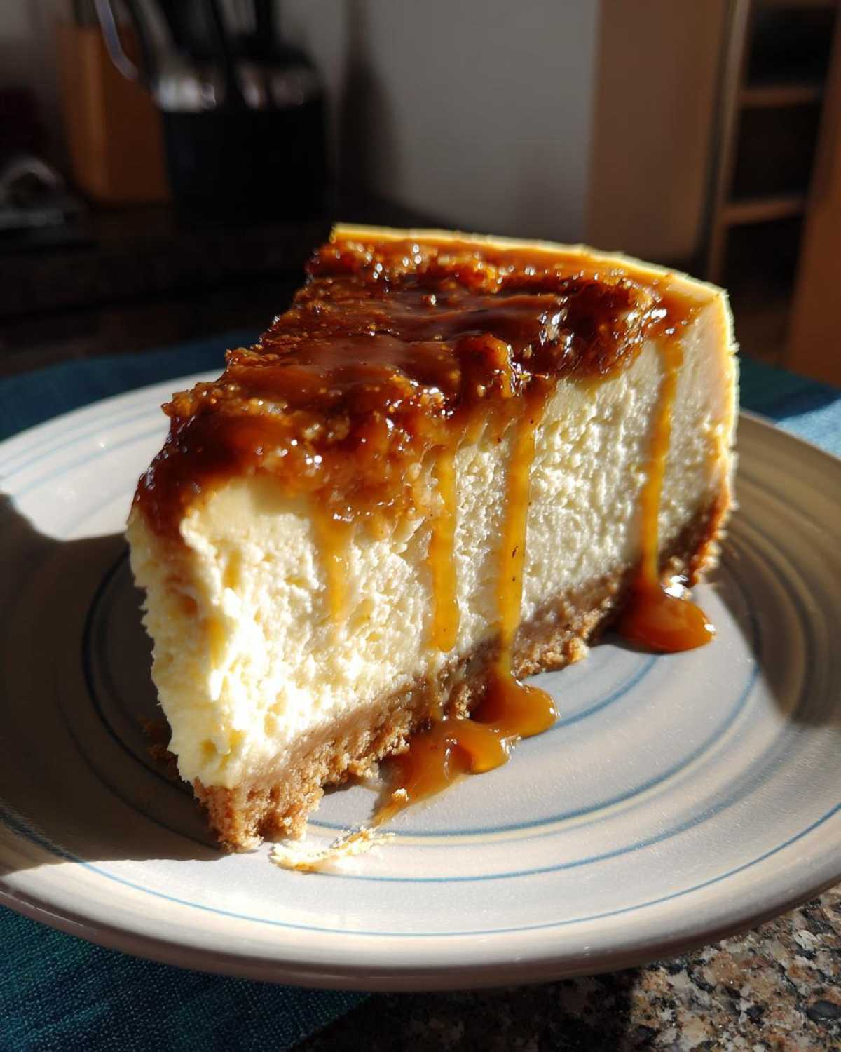 A delicious slice of salted caramel cheesecake with a graham cracker crust and caramel drizzle.