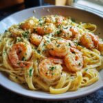 A bowl of creamy Shrimp Alfredo pasta, garnished with fresh parsley, ready to enjoy.