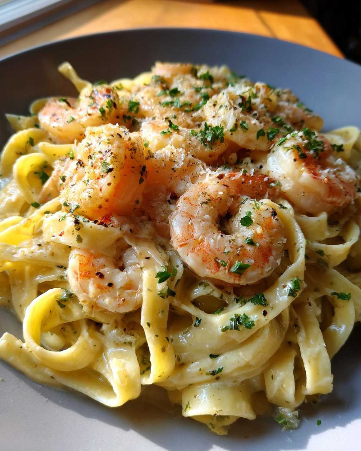 A plate of creamy Shrimp Alfredo pasta, garnished with parsley and parmesan cheese.