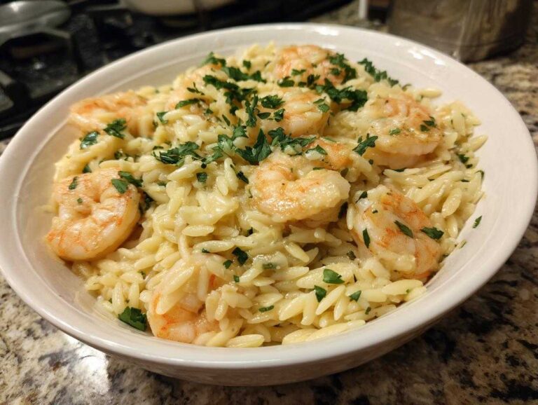 A bowl of shrimp orzo in lemon garlic sauce, garnished with fresh parsley.
