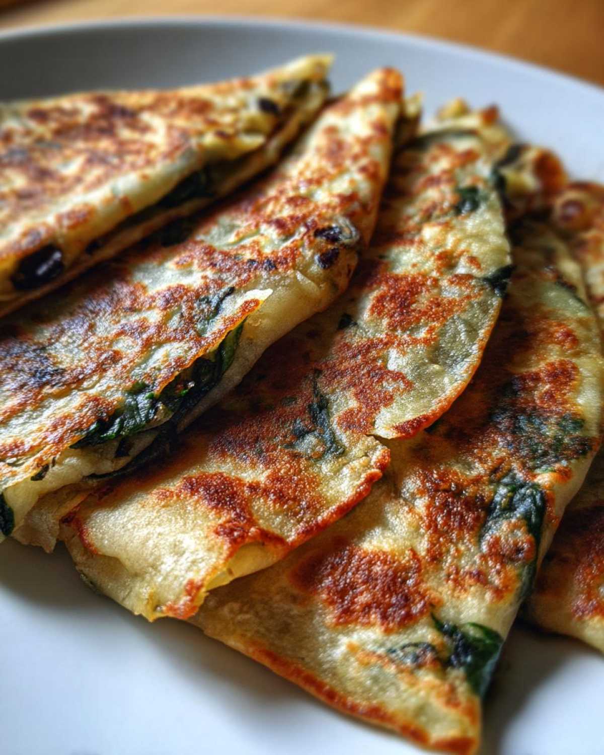 Close-up of Spinach Black Bean Folded Wraps, showcasing the golden-brown tortillas and visible spinach filling.