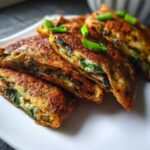 Close-up of stacked Spinach Black Bean Folded Wraps, garnished with green onions.