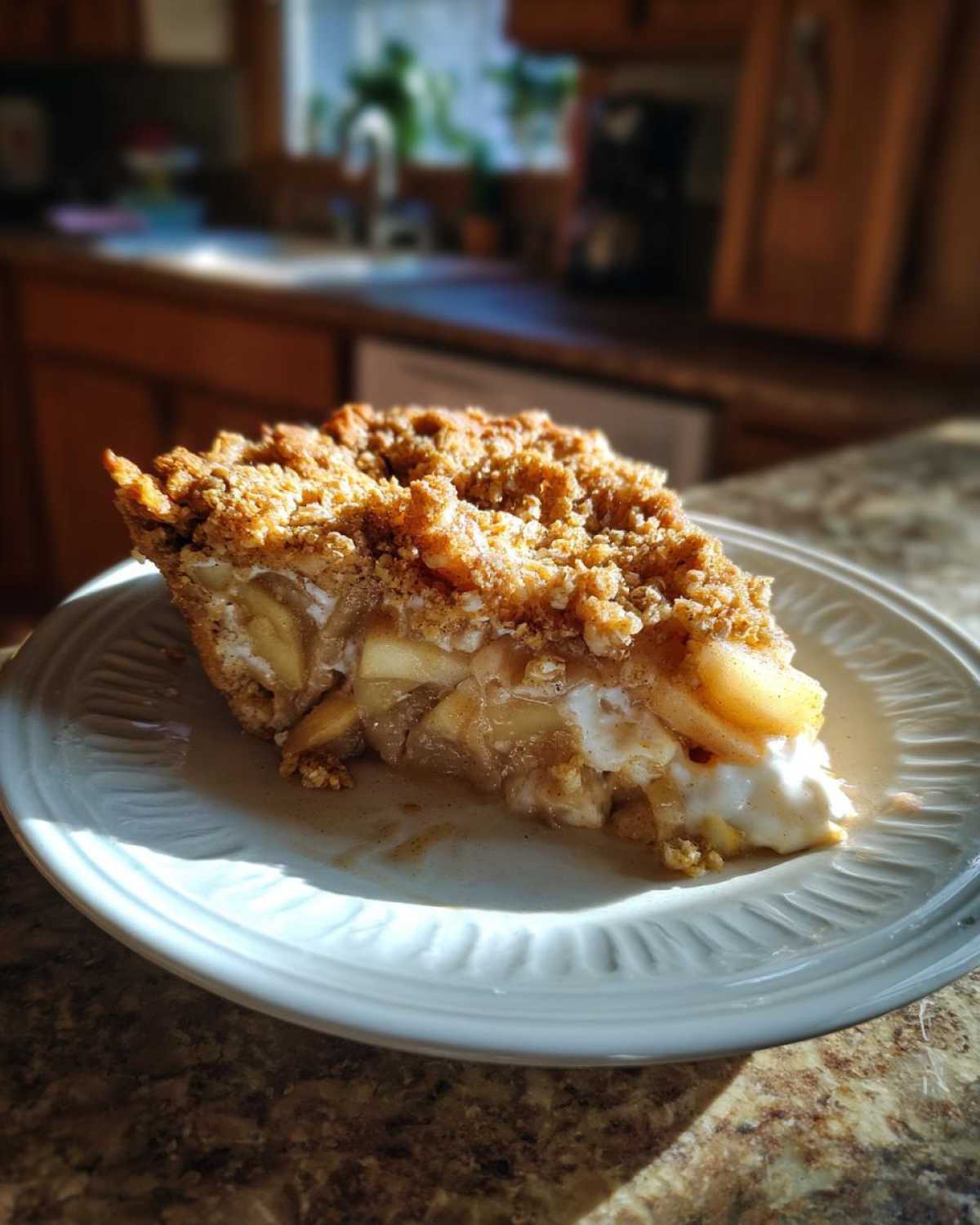 A slice of apple cinnamon cottage cheese bake with a crumb topping, served on a white plate.