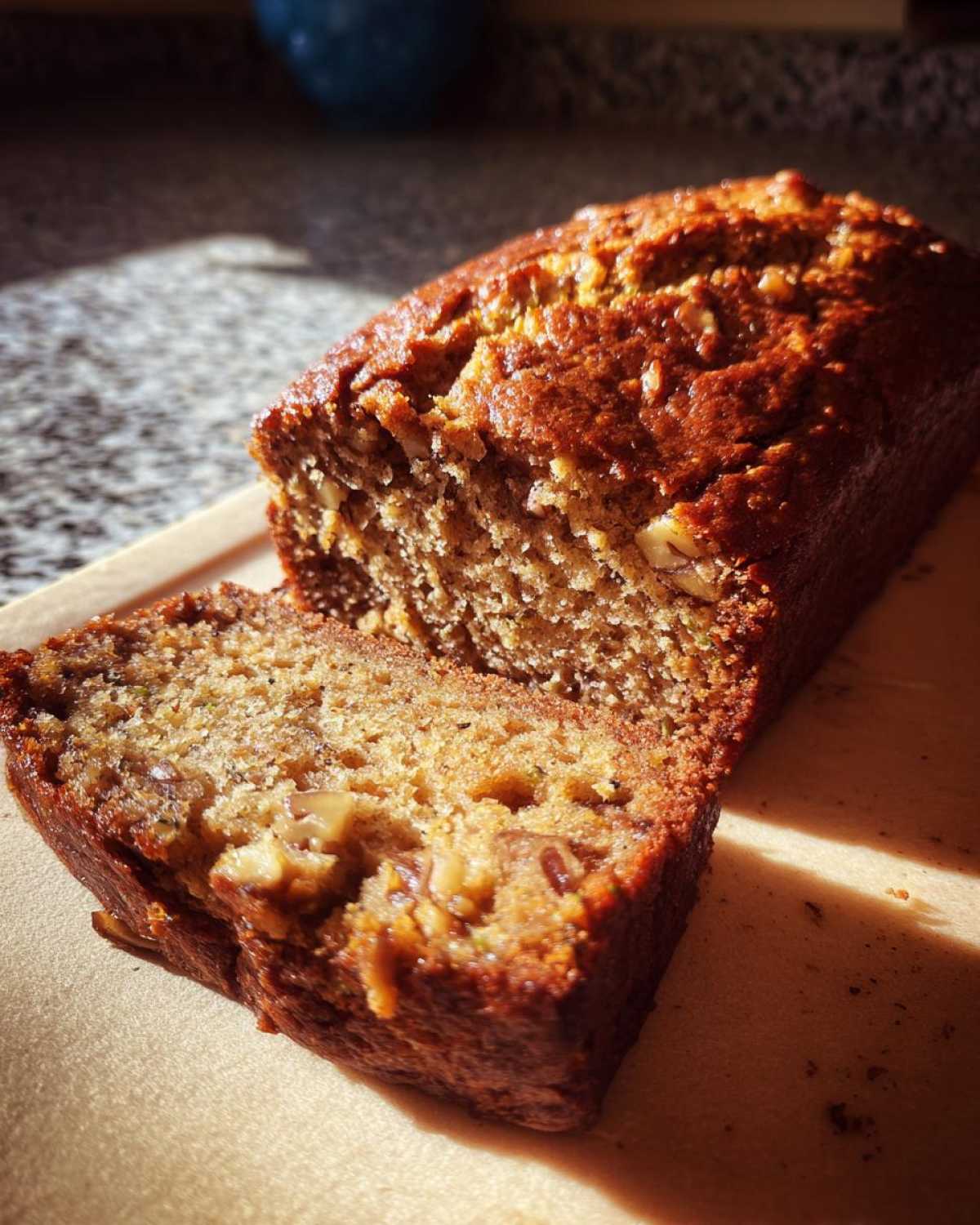 A sliced loaf of homemade applesauce zucchini bread, showing the moist texture and nuts inside.