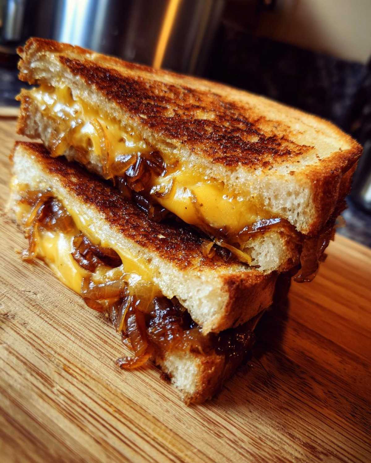 Stacked caramelized onion grilled cheese sandwich halves showing melted cheese and caramelized onions.