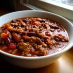 A comforting bowl of classic chili recipe, featuring ground beef, kidney beans, and diced tomatoes.