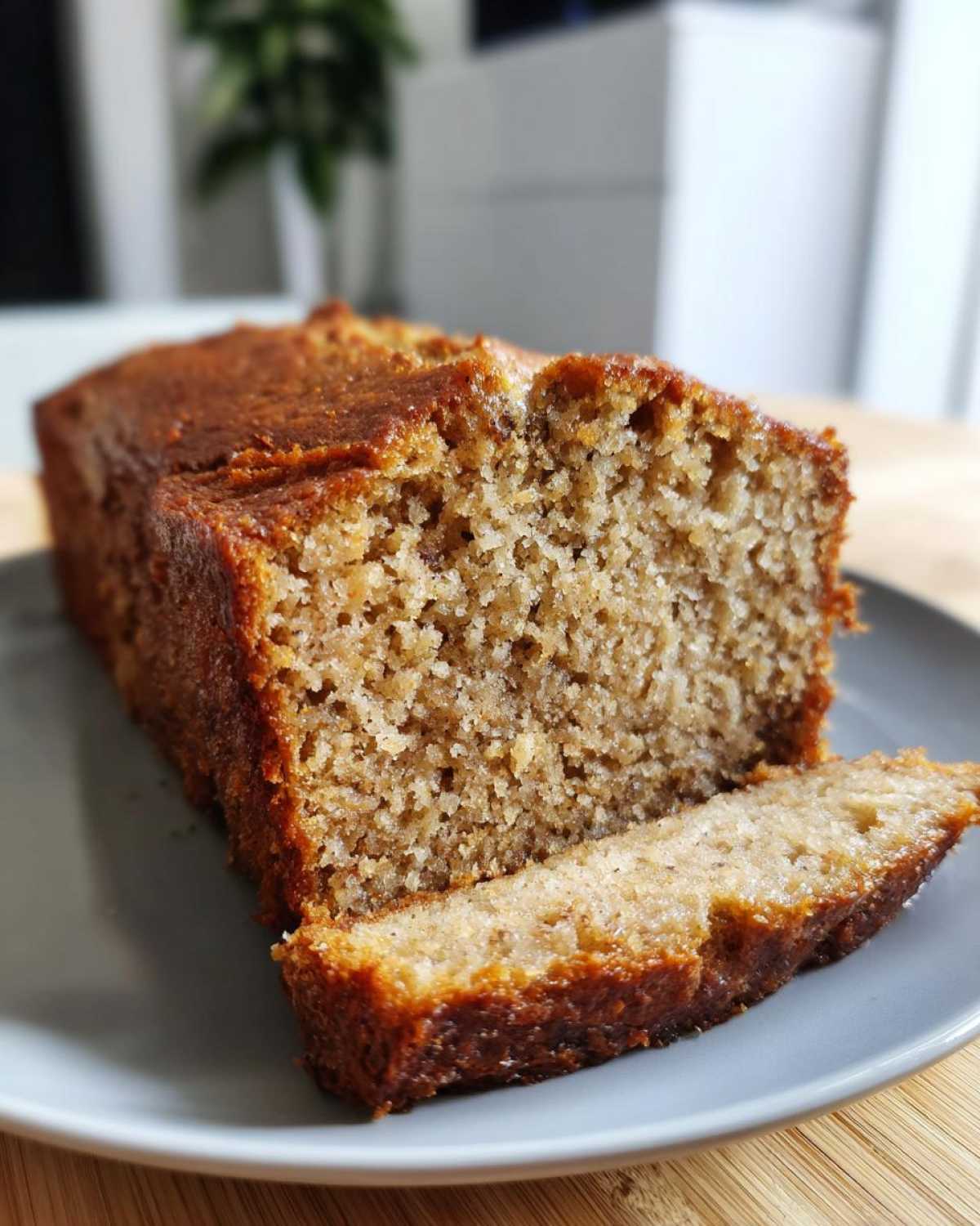 A slice of honey vanilla banana bread on a plate, showcasing the moist texture and golden crust.