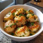 A bowl of perfectly seared lemon garlic scallops, garnished with fresh parsley.