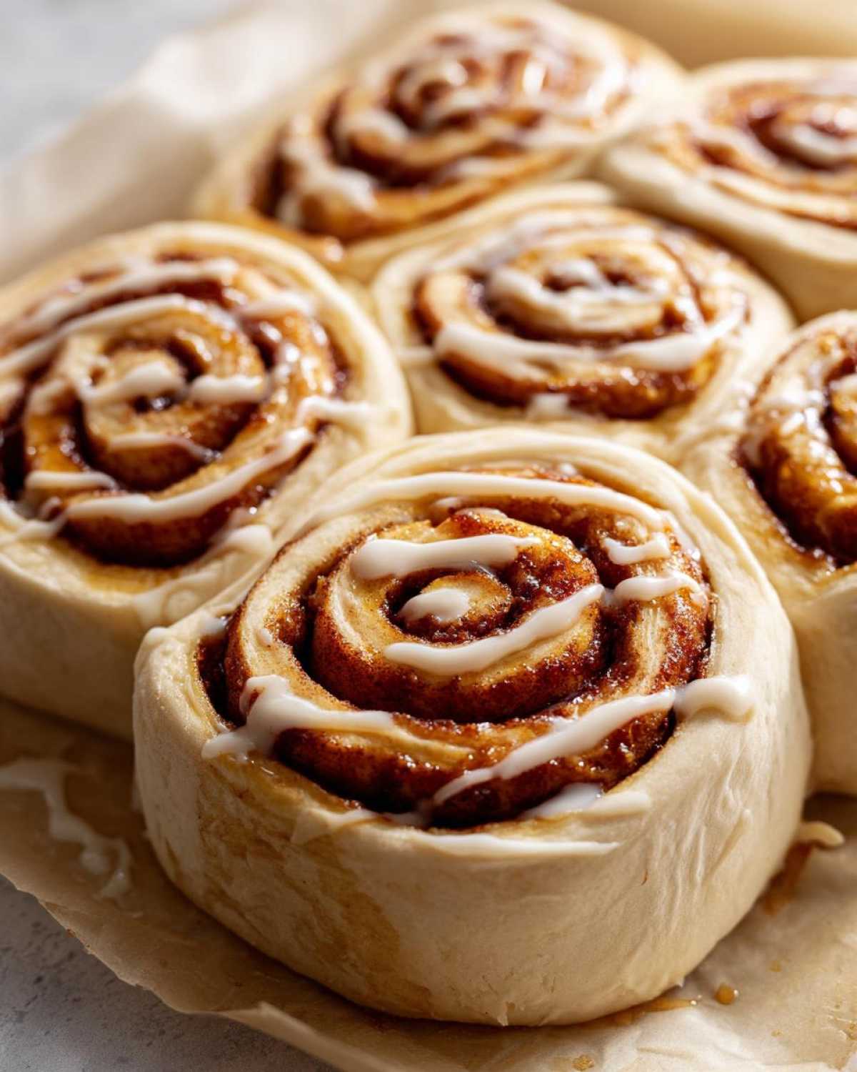 Close-up of freshly baked pumpkin cinnamon roll casserole with icing drizzle.