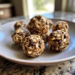 A plate of homemade Oatmeal protein balls, featuring oats, chocolate chips, and a sticky binder.