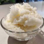 Close-up of fluffy, white snow ice cream served in a small, clear glass bowl.