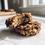 Two homemade breakfast cookies stacked, showing the chewy, oat-filled interior texture.
