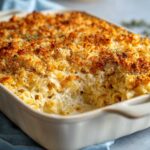 Close-up of a creamy tuna noodle casserole baked in a dish with a golden brown, crispy breadcrumb topping.