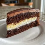 A rich slice of chocolate Italian love cake showing three distinct layers: dark chocolate cake, white cream, and yellow custard filling.