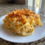 A square serving of creamy Monterey Chicken Spaghetti topped with melted cheddar and crispy onions.