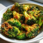 Close-up of crispy, bright green air fryer broccoli florets topped with golden brown breadcrumbs.