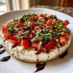 A round serving of creamy Boursin bruschetta dip topped with diced tomatoes, fresh basil, and balsamic glaze.