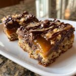 Close-up of two rich caramel filled chocolate chip cookie bars showing gooey caramel center and chocolate topping.