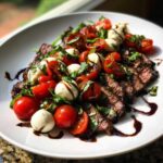 Sliced grilled flank steak topped with cherry tomatoes, mozzarella balls, and basil, drizzled with balsamic glaze.