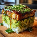 A perfectly formed honey lime chicken & avocado rice stack, topped with glaze and sesame seeds.