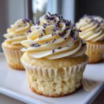 A close-up of a perfectly frosted lavender honey cupcakes topped with dried lavender buds.