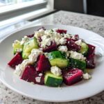 Close-up of a bright mediterranean cucumber feta beet salad featuring cubed beets, cucumber chunks, and crumbled feta cheese.